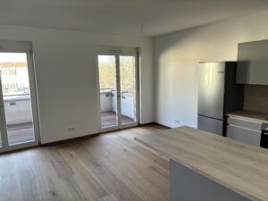 IMG_0239: Moderne Einbauküche in 2-Raum-Wohnung mit Holzboden und Balkonzugang. Inklusive Kühlschrank und Kücheninsel.